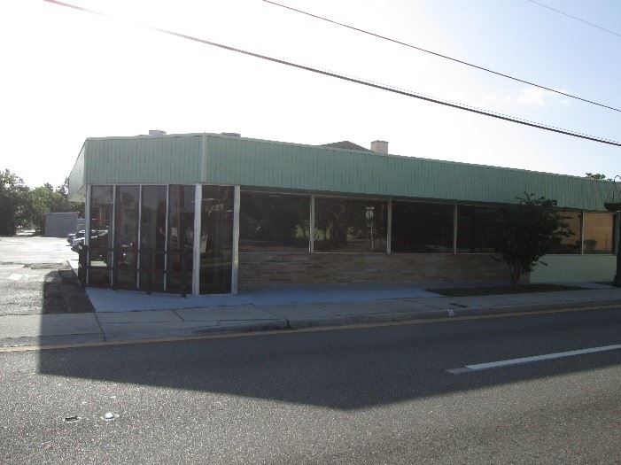 Photo of a restaurant with green siding along a city street.